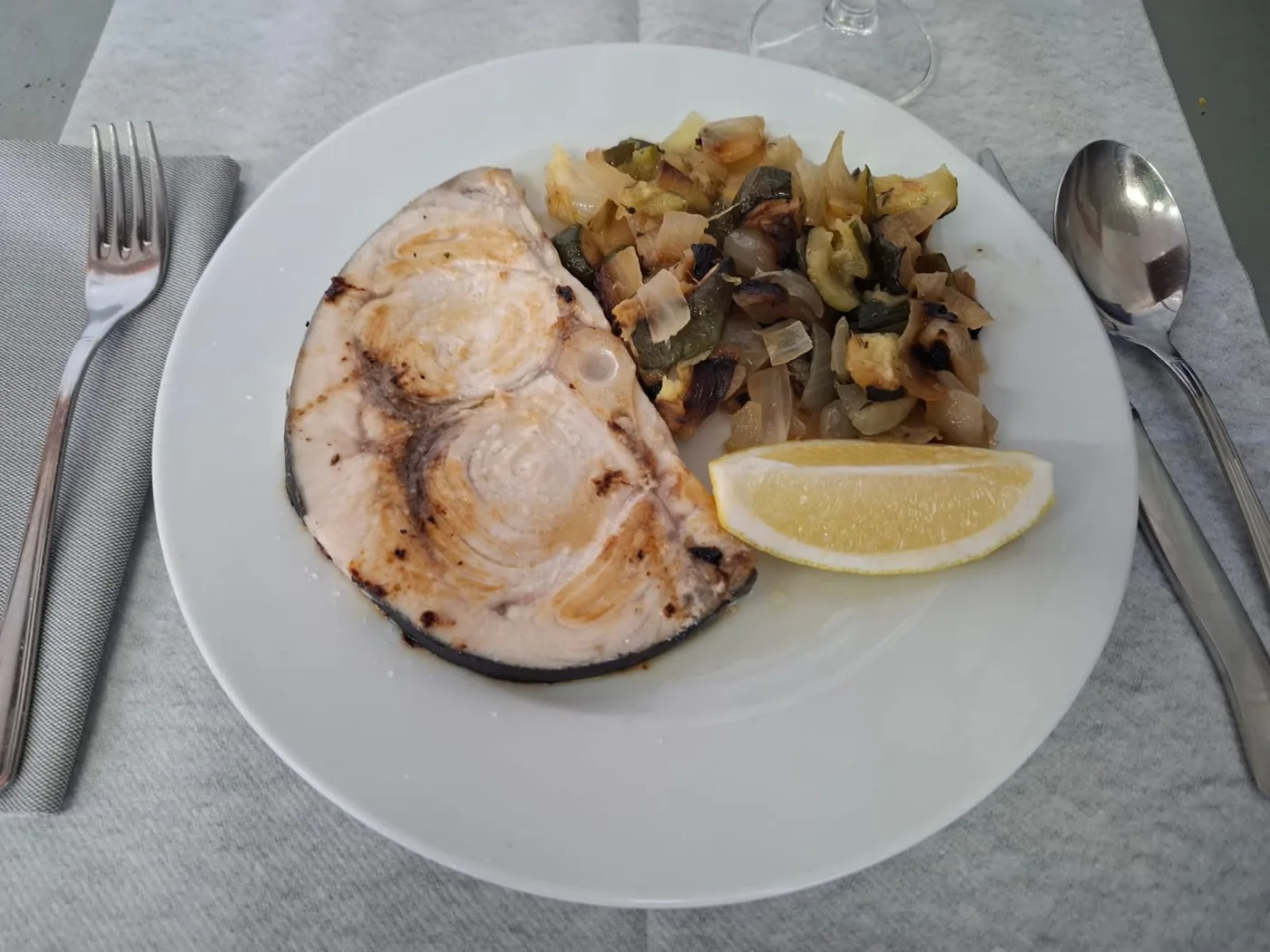 Emperador a la plancha con calabacín y cebolla